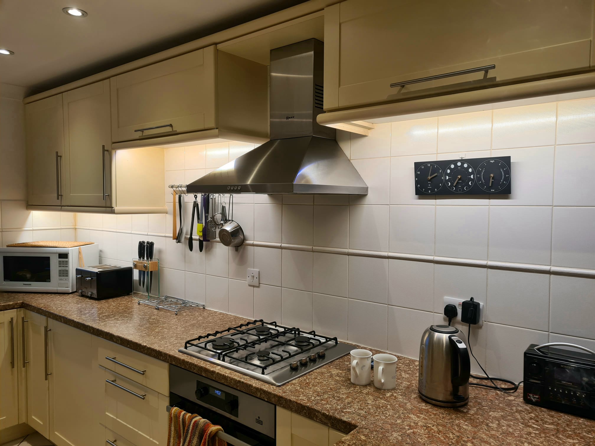 A kitchen with LED strip lighting under the wall cabinets