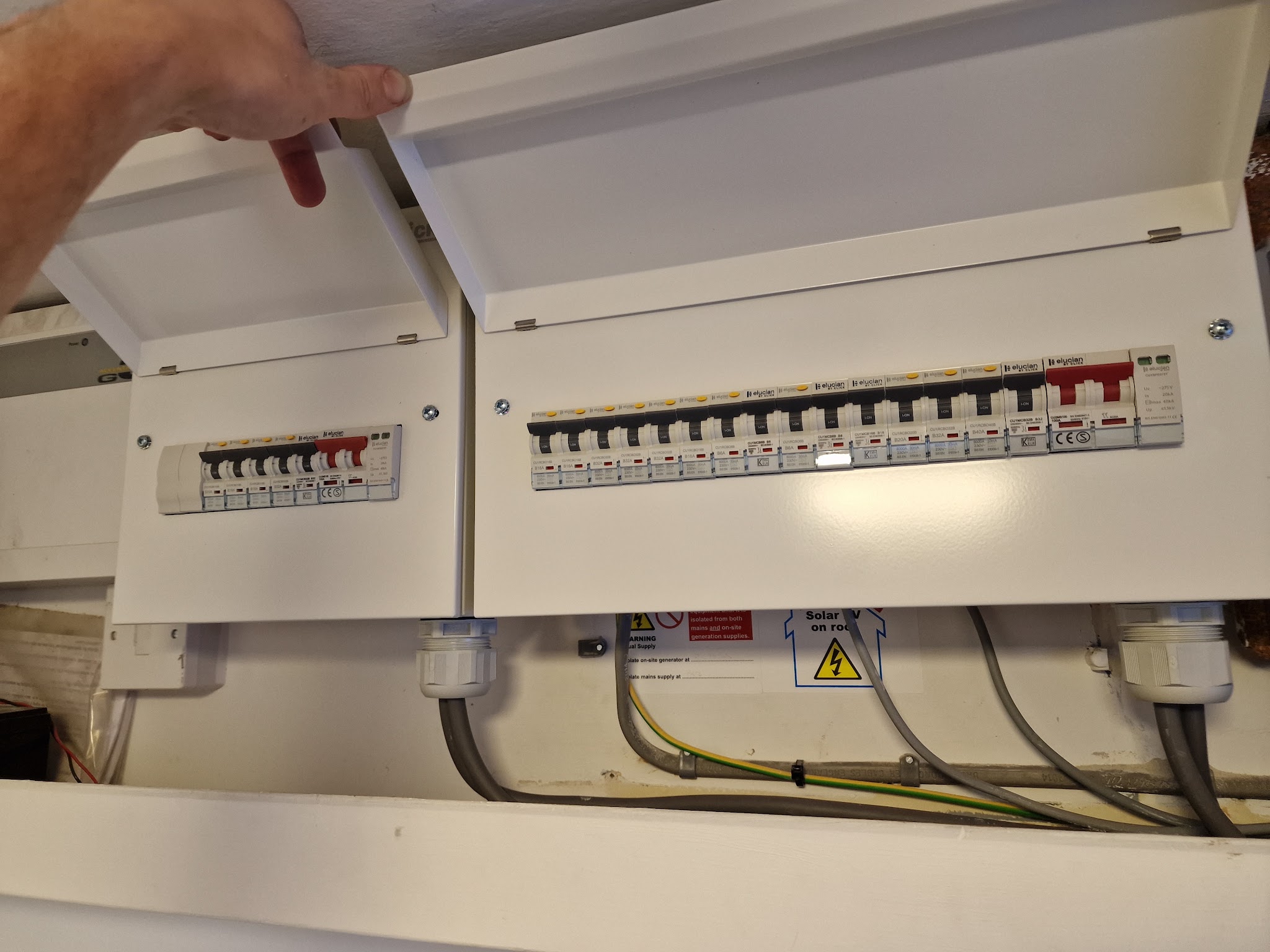 A new dual consumer unit with its covers lifted, showing the breakers and neat cabling